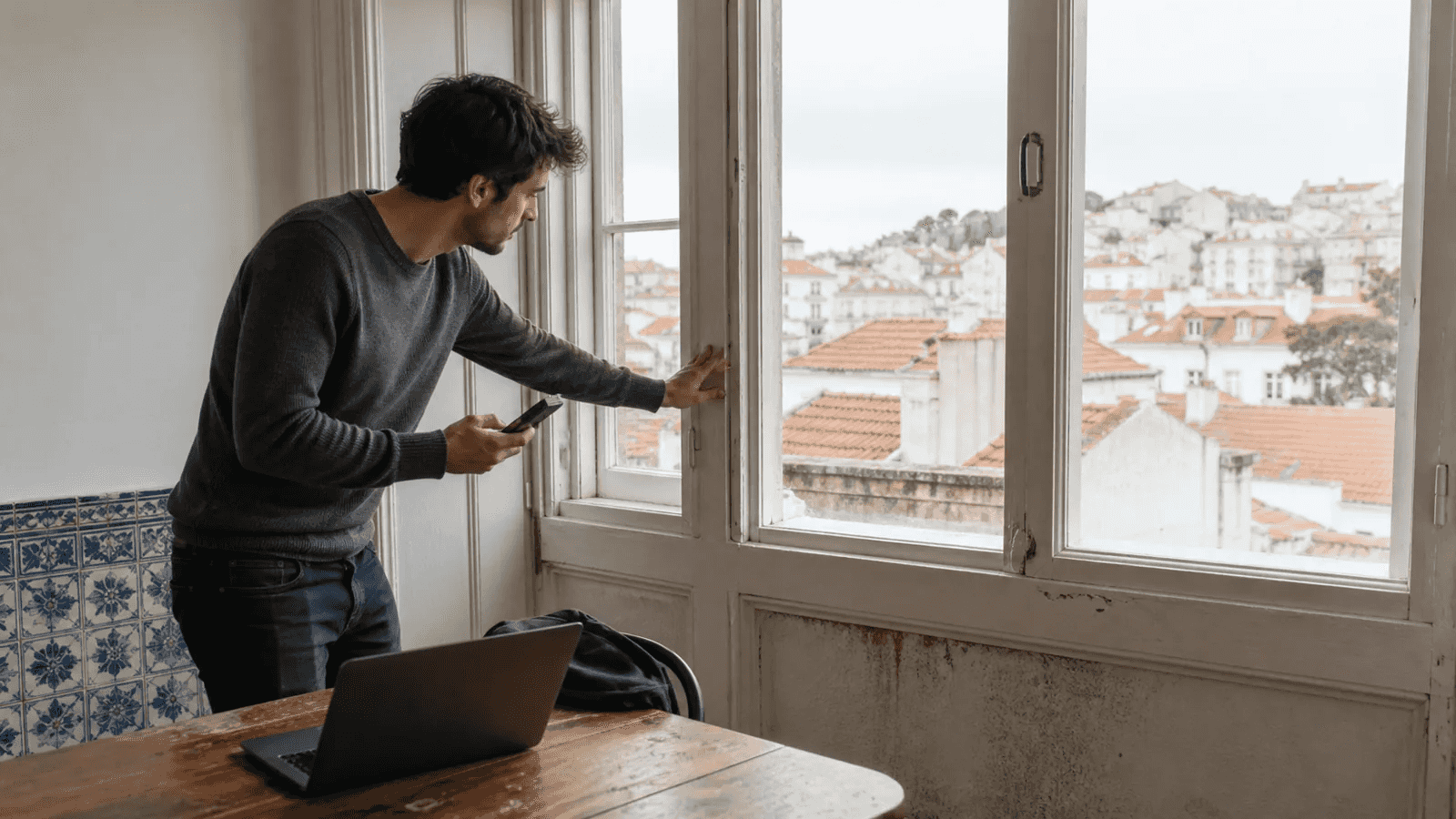 Remote worker inspecting the windows of an older Lisbon rental apartment