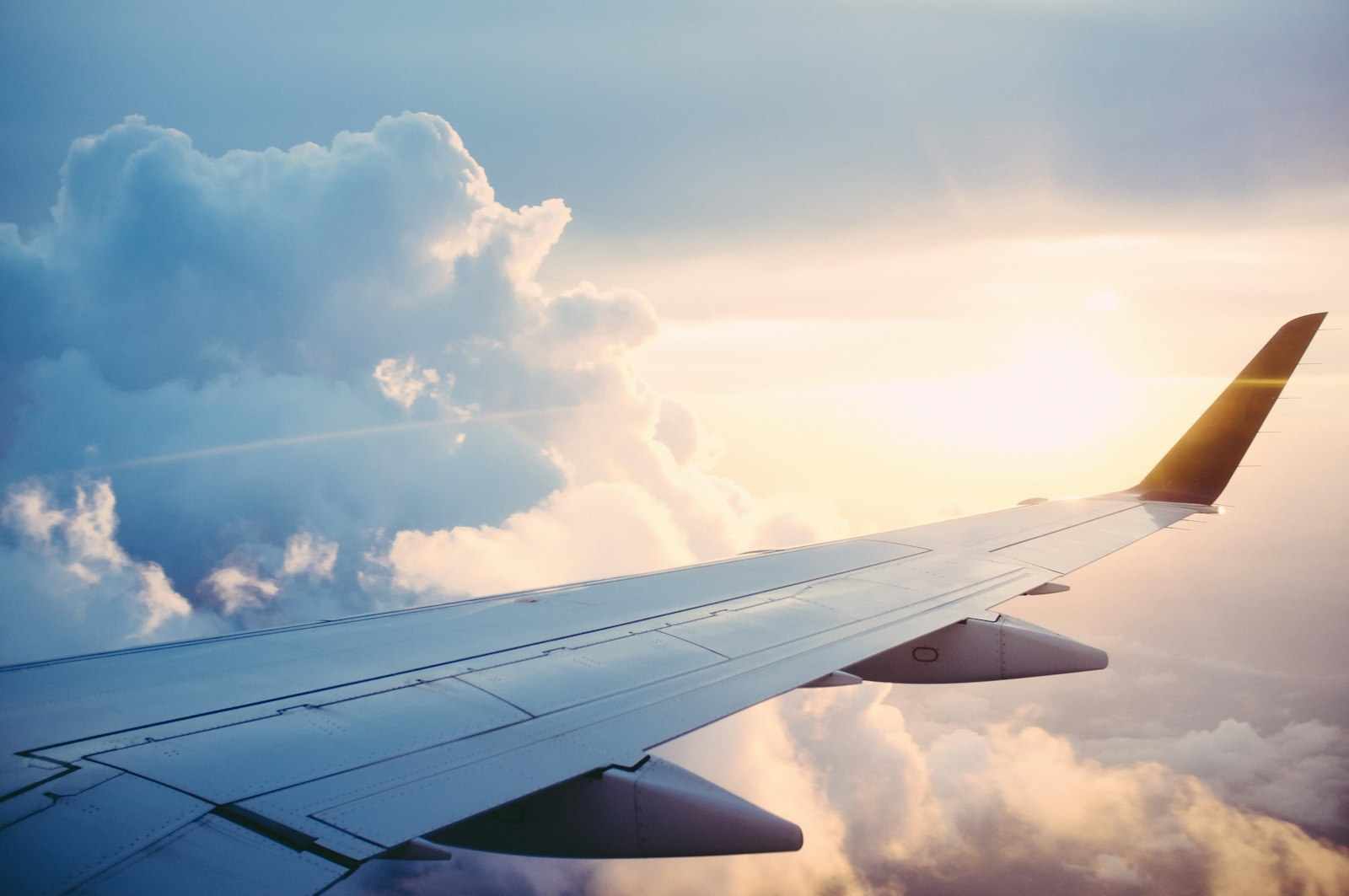 Airplane wing above clouds during international travel