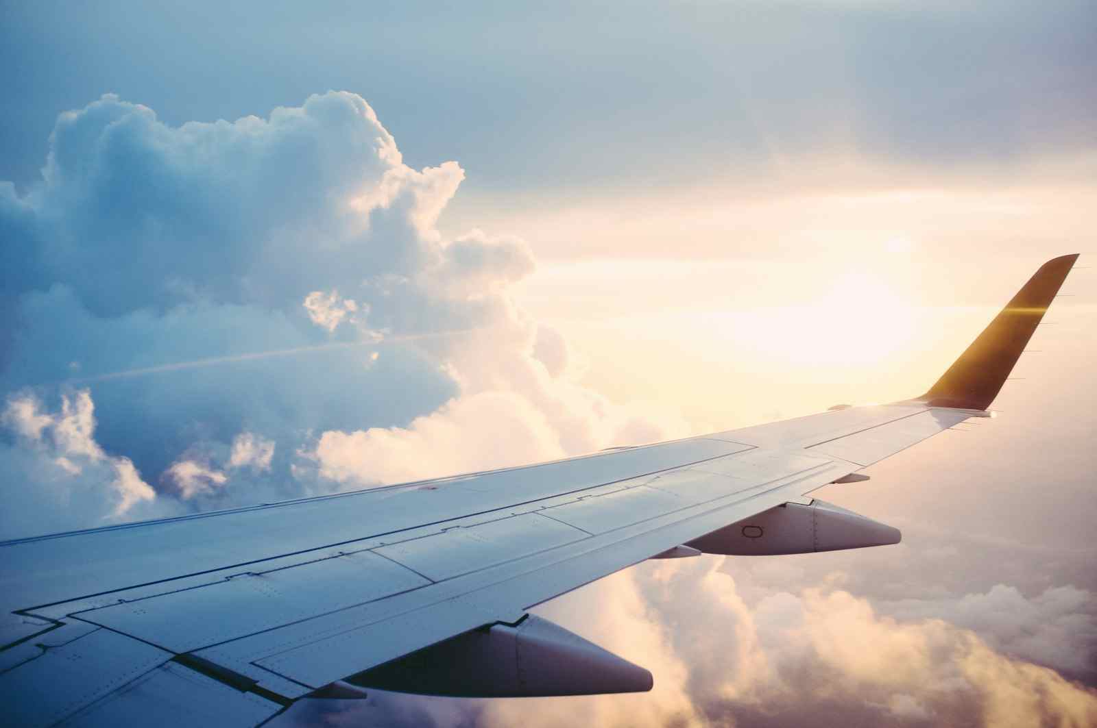 Airplane wing above clouds during international travel