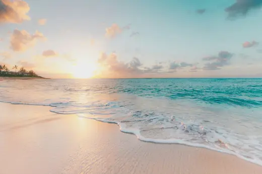Turquoise ocean and sandy beach under clear sky