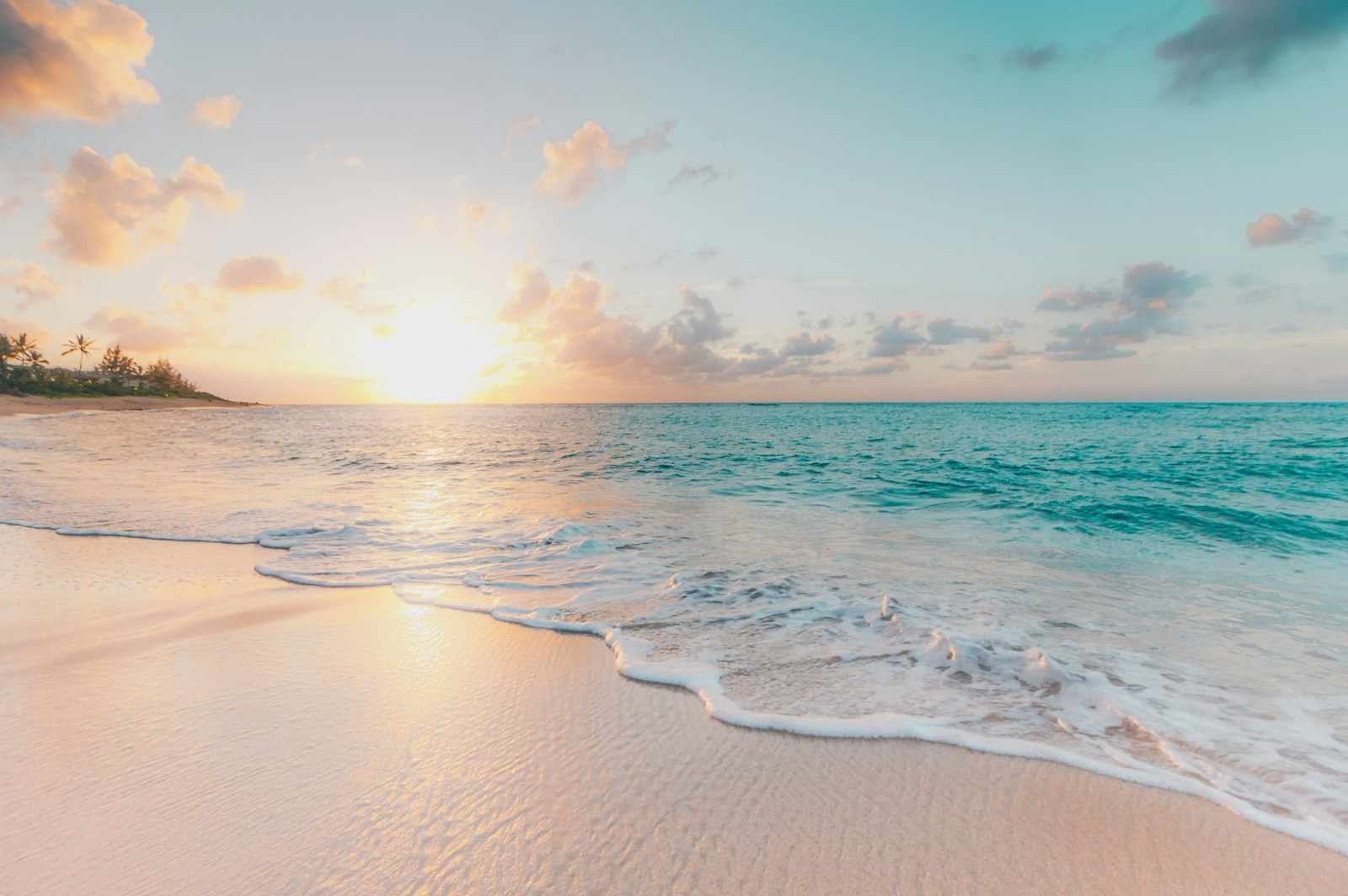 Turquoise ocean and sandy beach under clear sky